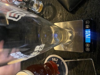 Empty glass on a jeweler's scale reading 14.20 oz
